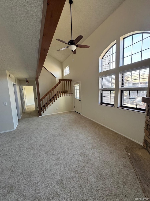 unfurnished living room featuring a ceiling fan, a textured ceiling, and carpet flooring