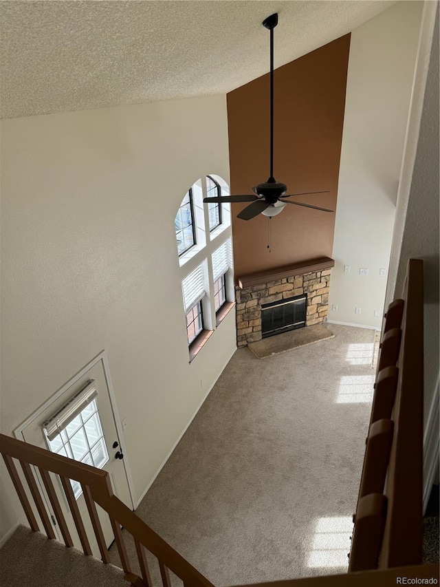 unfurnished living room with carpet floors, a ceiling fan, high vaulted ceiling, and a wealth of natural light