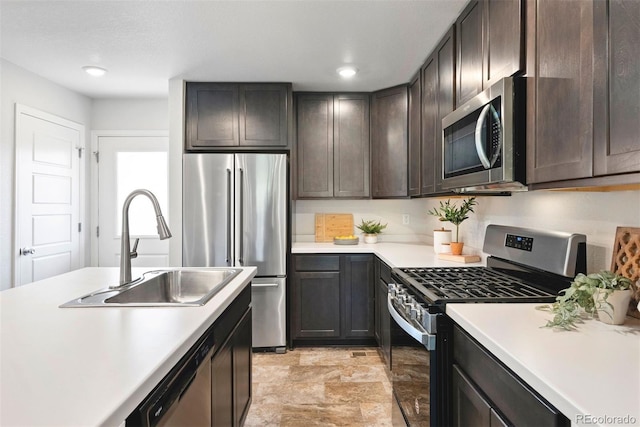 12777 Ulster St, Thornton, CO 80602 - kitchen featuring appliances with stainless steel finishes, light countertops, dark brown cabinetry, stone finish flooring, and recessed lighting