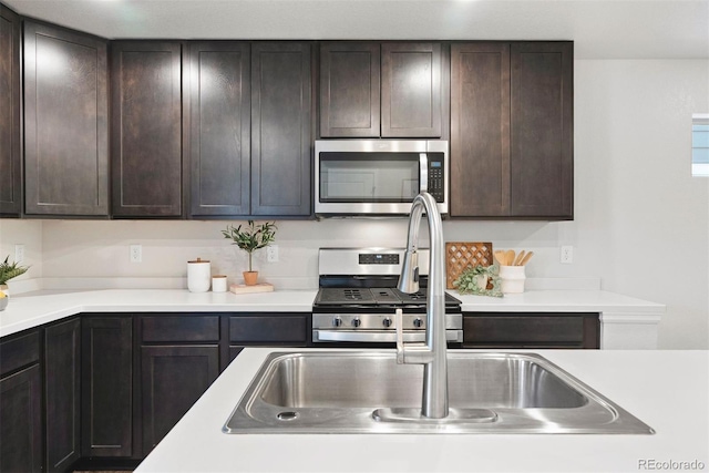 12777 Ulster St, Thornton, CO 80602 - kitchen featuring appliances with stainless steel finishes, light countertops, and dark brown cabinetry