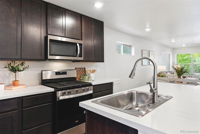 12777 Ulster St, Thornton, CO 80602 - kitchen featuring appliances with stainless steel finishes, light countertops, open floor plan, dark brown cabinetry, and recessed lighting