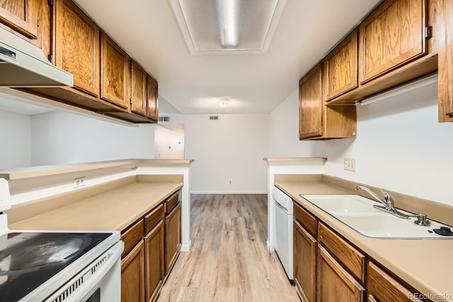 kitchen featuring sink, white appliances, and light wood-type flooring