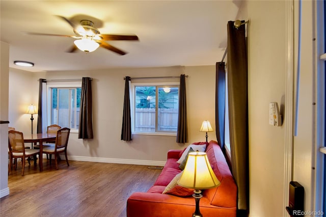 living area featuring wood-type flooring and ceiling fan