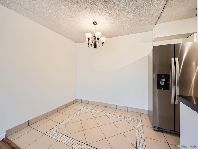 7755 E Quincy Ave Unit 301A7, Denver, CO 80237 - unfurnished dining area with a chandelier, light tile patterned floors, baseboards, and a textured ceiling