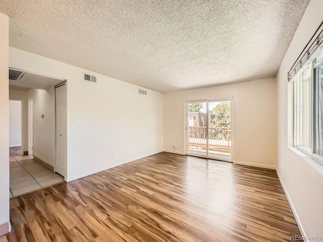 7755 E Quincy Ave Unit 301A7, Denver, CO 80237 - unfurnished room featuring light wood-style flooring, a textured ceiling, and baseboards