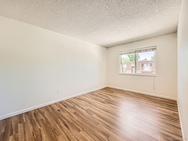 7755 E Quincy Ave Unit 301A7, Denver, CO 80237 - empty room featuring wood finished floors, baseboards, and a textured ceiling