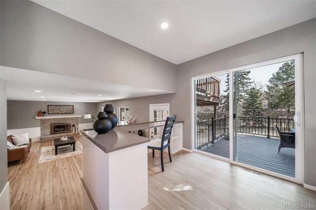 5404 W Rowland Pl, Littleton, CO 80128 - kitchen with light wood-style floors, a glass covered fireplace, and recessed lighting