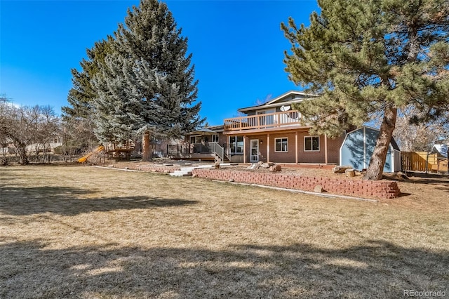 5404 W Rowland Pl, Littleton, CO 80128 - rear view of house with a wooden deck, a lawn, brick siding, and an outdoor structure