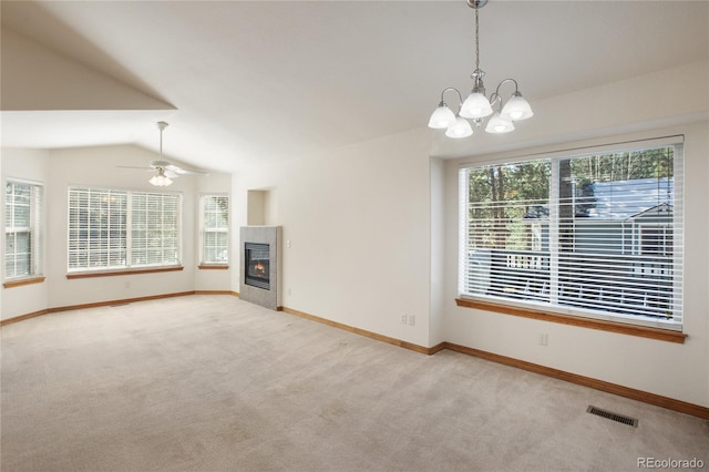 unfurnished living room with carpet floors, lofted ceiling, a chandelier, and baseboards