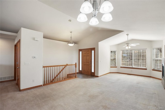 spare room featuring carpet flooring, lofted ceiling, ceiling fan, baseboards, and a chandelier