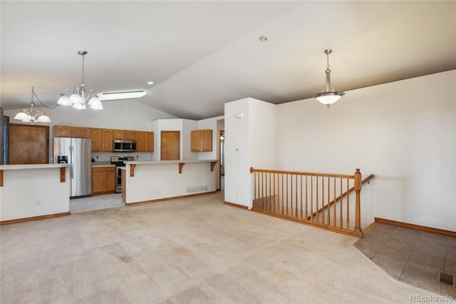 kitchen featuring stainless steel appliances, lofted ceiling, light countertops, brown cabinets, and a chandelier