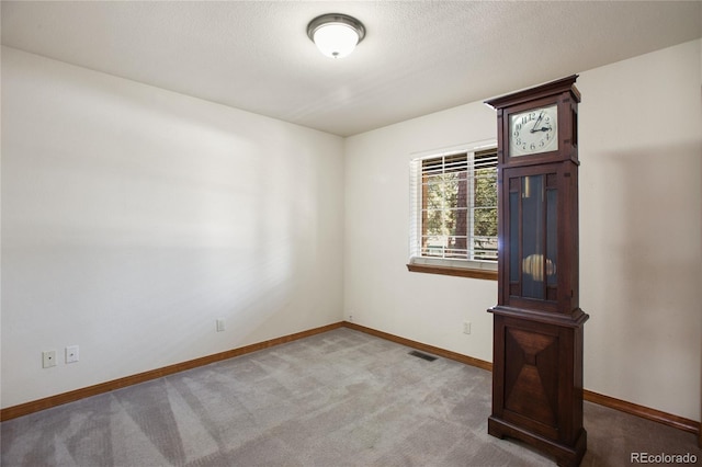 carpeted empty room featuring baseboards