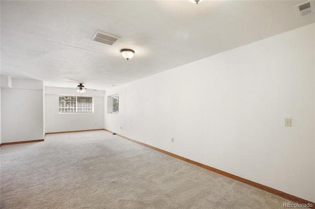 spare room featuring baseboards, light carpet, and ceiling fan