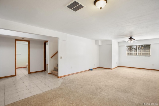 carpeted empty room featuring stairway, baseboards, and ceiling fan
