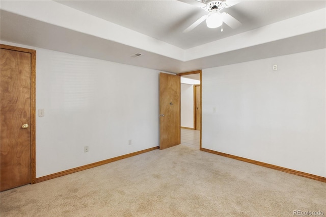 carpeted spare room featuring baseboards and ceiling fan