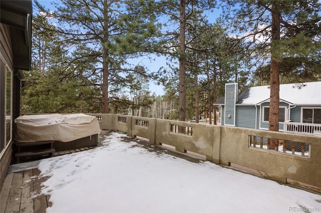 yard covered in snow featuring a jacuzzi, fence, and a deck
