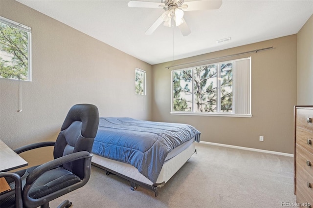 bedroom with ceiling fan, carpet floors, and multiple windows