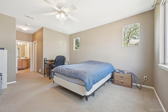 carpeted bedroom with ceiling fan and ensuite bathroom