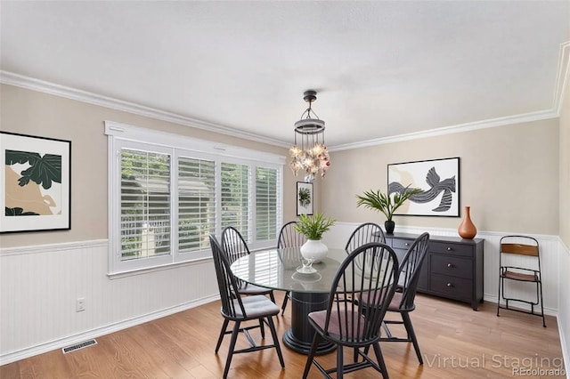 5326 E Hamilton Ave, Castle Rock, CO 80104 - dining room with ornamental molding, light wood finished floors, wainscoting, and a chandelier