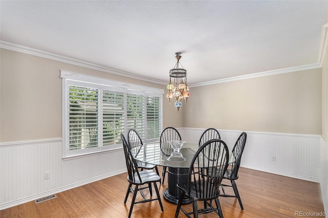 5326 E Hamilton Ave, Castle Rock, CO 80104 - dining room featuring wood finished floors, a wainscoted wall, ornamental molding, and a chandelier