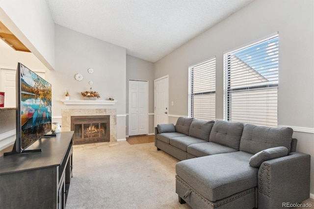 living room with lofted ceiling, light carpet, and a tile fireplace