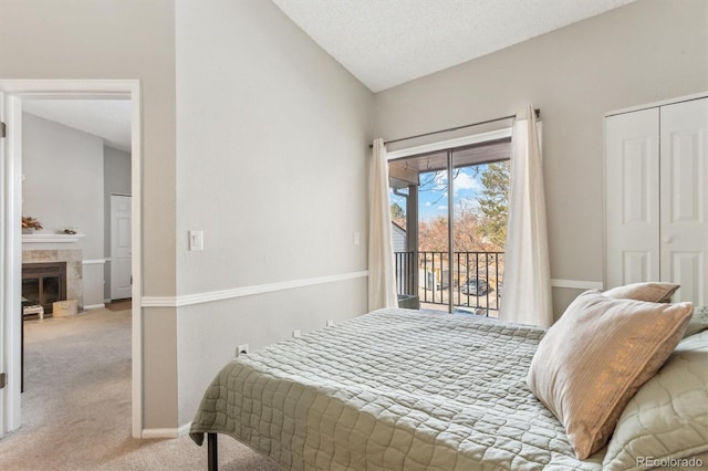 bedroom featuring light carpet, baseboards, a tiled fireplace, lofted ceiling, and access to exterior