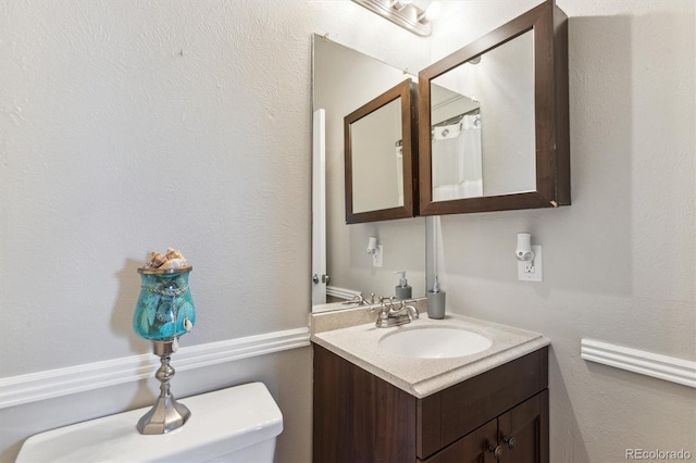 bathroom featuring vanity and toilet