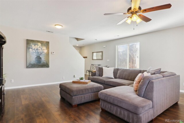 living area with ceiling fan, dark wood-style flooring, and baseboards