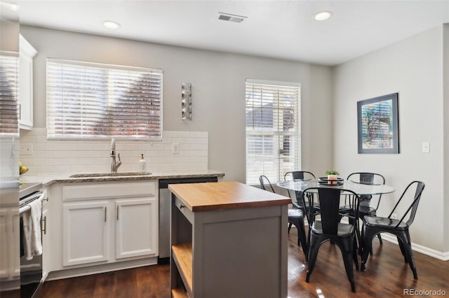 kitchen featuring tasteful backsplash, visible vents, stainless steel appliances, wooden counters, and a sink