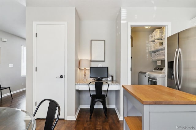 kitchen with baseboards, dark wood-style flooring, washer and dryer, and stainless steel fridge with ice dispenser