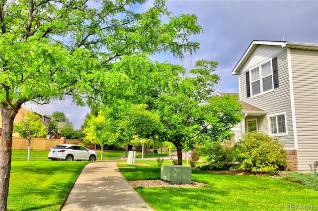 view of community with fence and a lawn