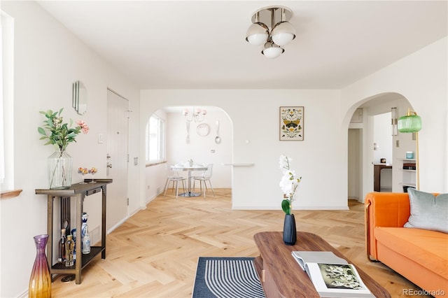 living area featuring arched walkways and baseboards