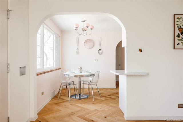 dining area with an inviting chandelier, arched walkways, and baseboards