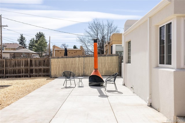 view of patio / terrace with a fire pit and fence