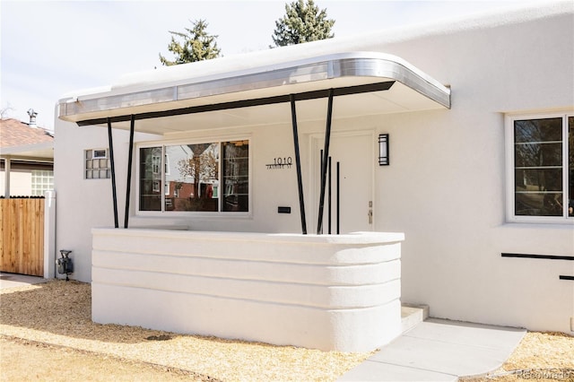 exterior space featuring fence and stucco siding