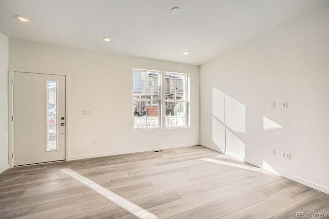 empty room with light hardwood / wood-style flooring