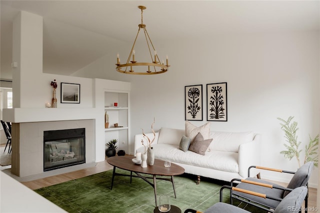 9756 Autumnwood Pl, Highlands Ranch, CO 80129 - living room featuring wood finished floors, a chandelier, built in features, a tile fireplace, and lofted ceiling
