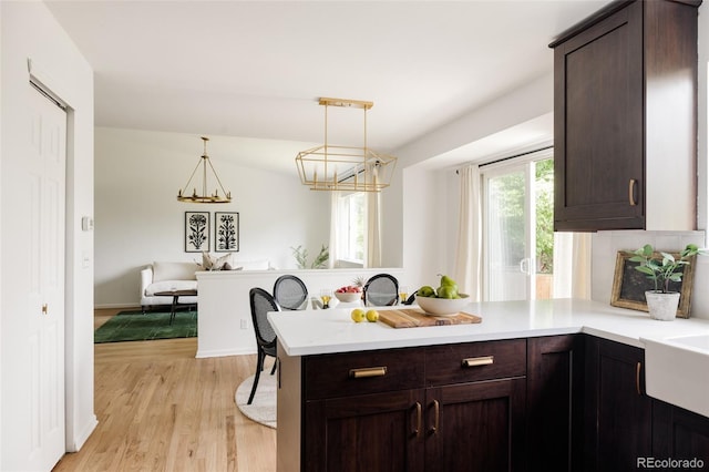 9756 Autumnwood Pl, Highlands Ranch, CO 80129 - kitchen with dark brown cabinetry, light countertops, and a peninsula