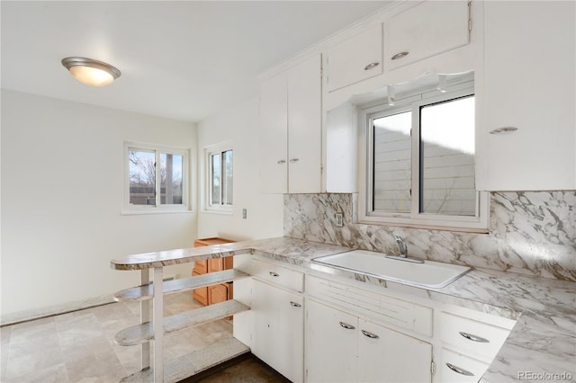 kitchen featuring decorative backsplash, sink, and white cabinets