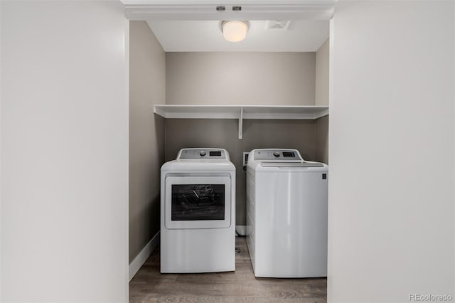 laundry area featuring washing machine and dryer and wood finished floors