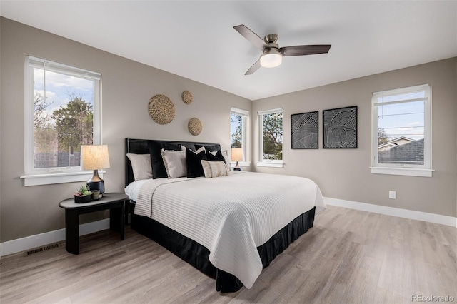 bedroom featuring light wood-style flooring, baseboards, and ceiling fan