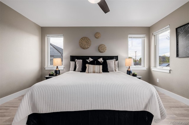 bedroom with light wood-style floors, baseboards, and ceiling fan