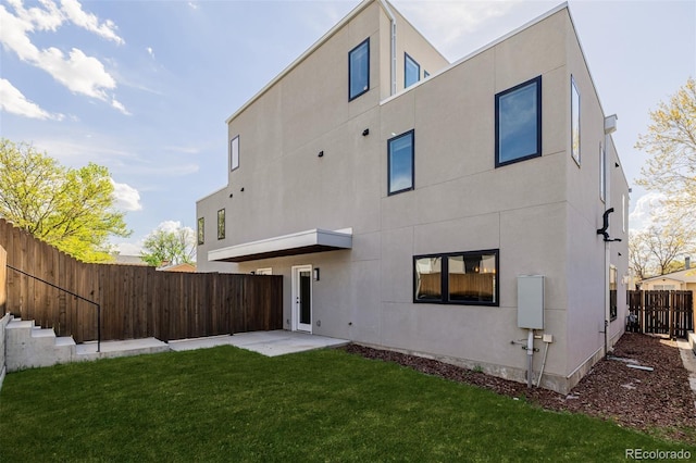 rear view of property featuring stucco siding and a patio area