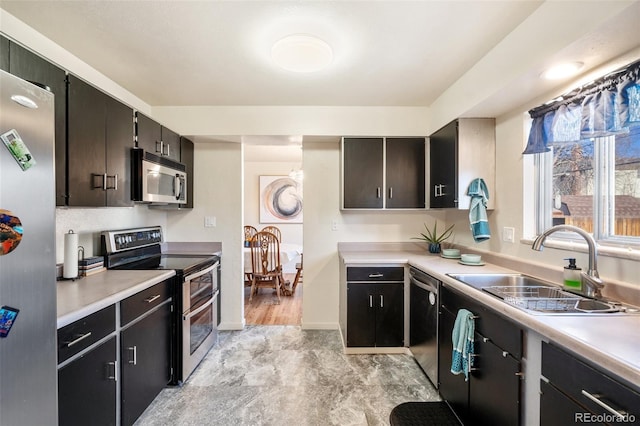 kitchen featuring stainless steel appliances, light countertops, and a sink