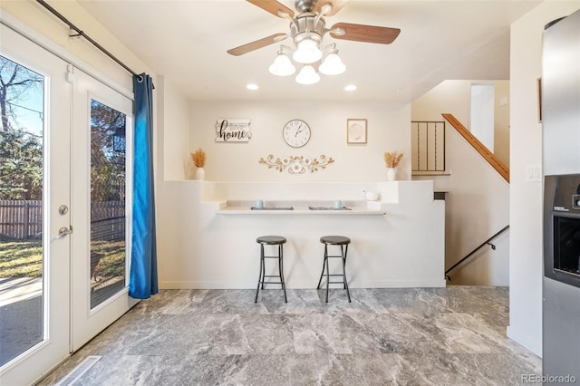 kitchen featuring recessed lighting, french doors, and a kitchen breakfast bar