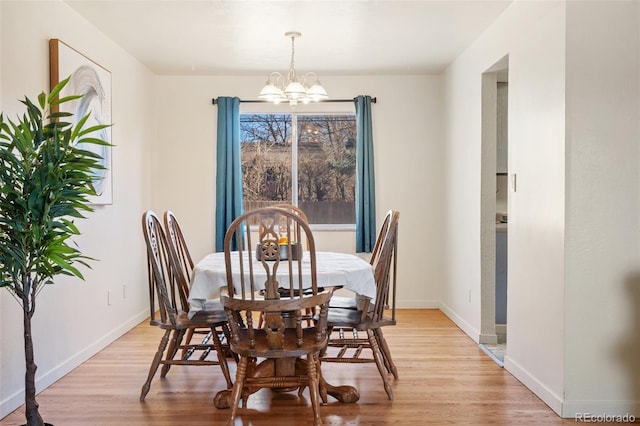 dining room with an inviting chandelier, light wood-style flooring, and baseboards