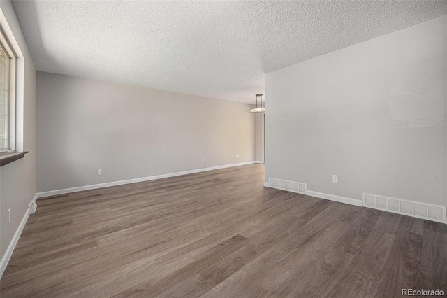 8346 W Woodard Dr, Lakewood, CO 80227 - unfurnished room with wood finished floors, baseboards, and a textured ceiling