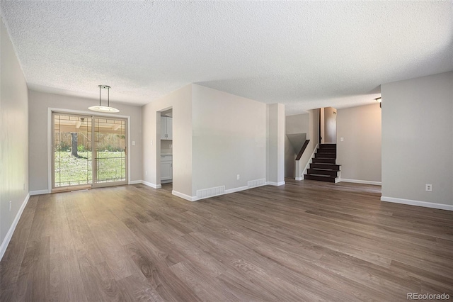 8346 W Woodard Dr, Lakewood, CO 80227 - unfurnished living room with a textured ceiling, dark wood-style floors, and baseboards