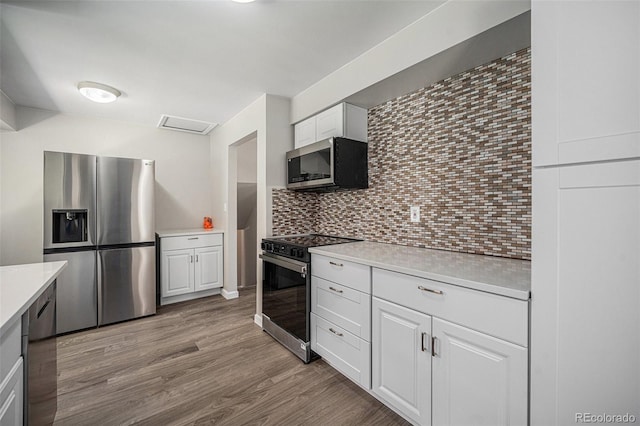 8346 W Woodard Dr, Lakewood, CO 80227 - kitchen featuring appliances with stainless steel finishes, light countertops, tasteful backsplash, and light wood-style flooring