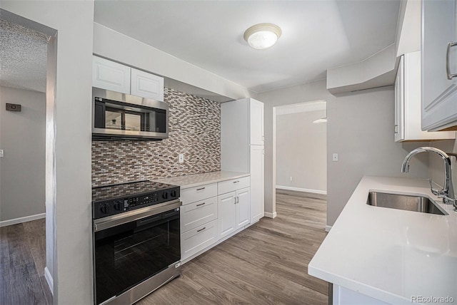 8346 W Woodard Dr, Lakewood, CO 80227 - kitchen with stainless steel appliances, a sink, decorative backsplash, and light countertops